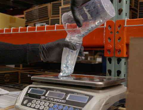 Bolts being sorted and poured into a bag.